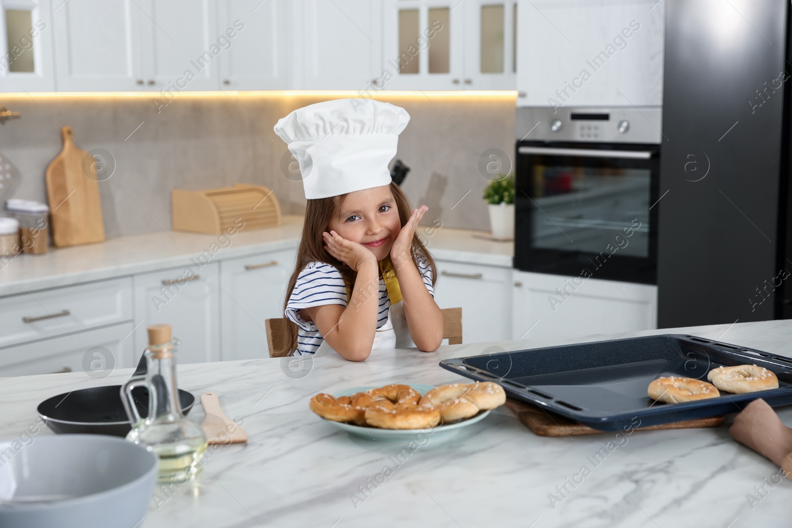 Choice of profession. Little girl with pastries pretending to be chef in kitchen Photo of Choice of profession. Little girl with pastries pretending to be chef in kitchen