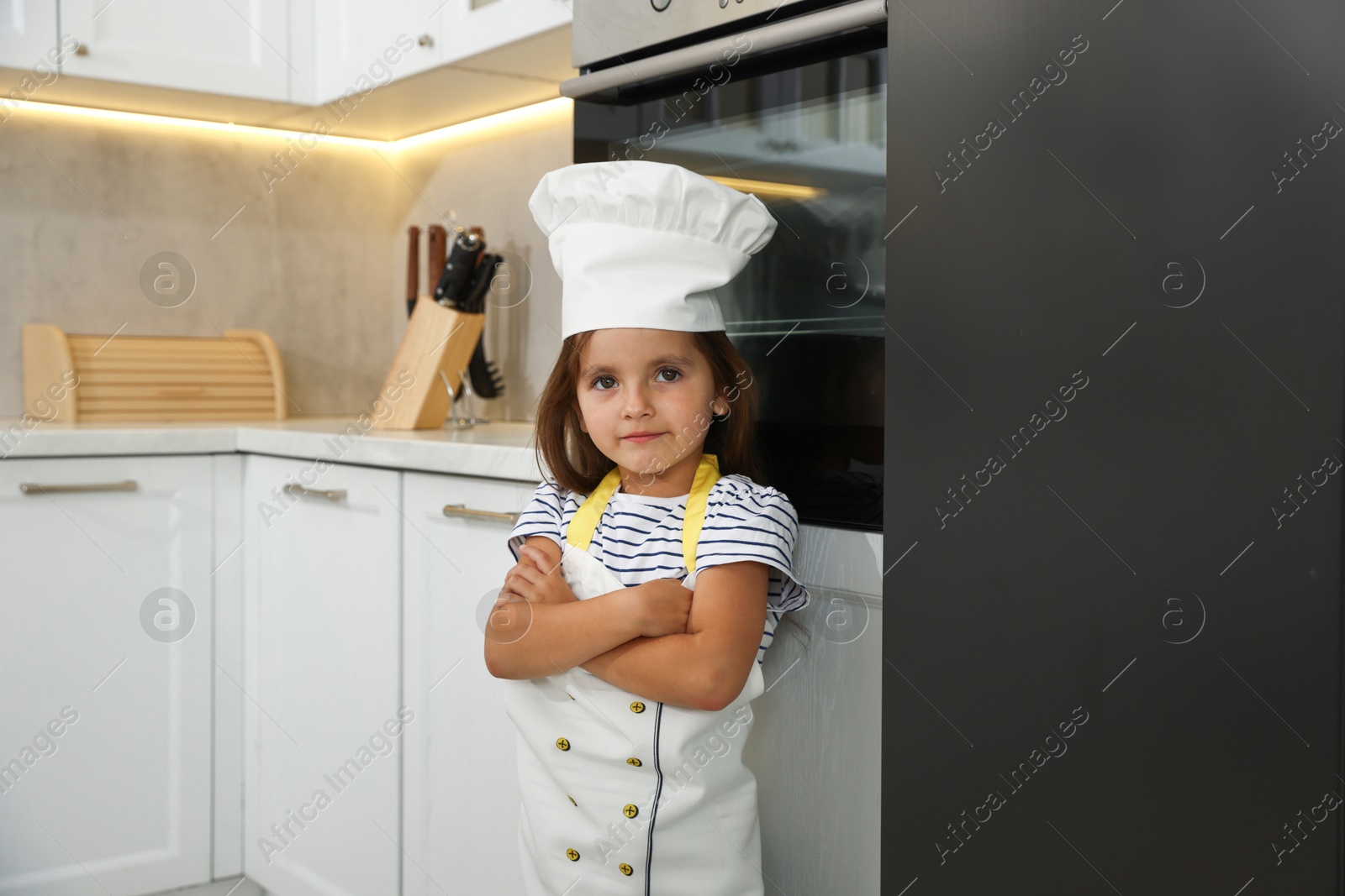 Photo of Choice of profession. Little girl pretending to be chef in kitchen