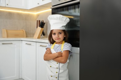 Photo of Choice of profession. Little girl pretending to be chef in kitchen