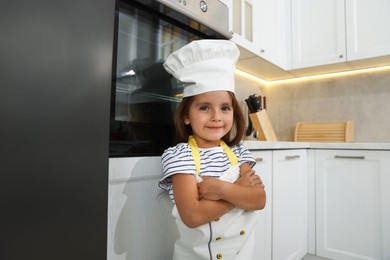 Photo of Choice of profession. Little girl pretending to be chef in kitchen