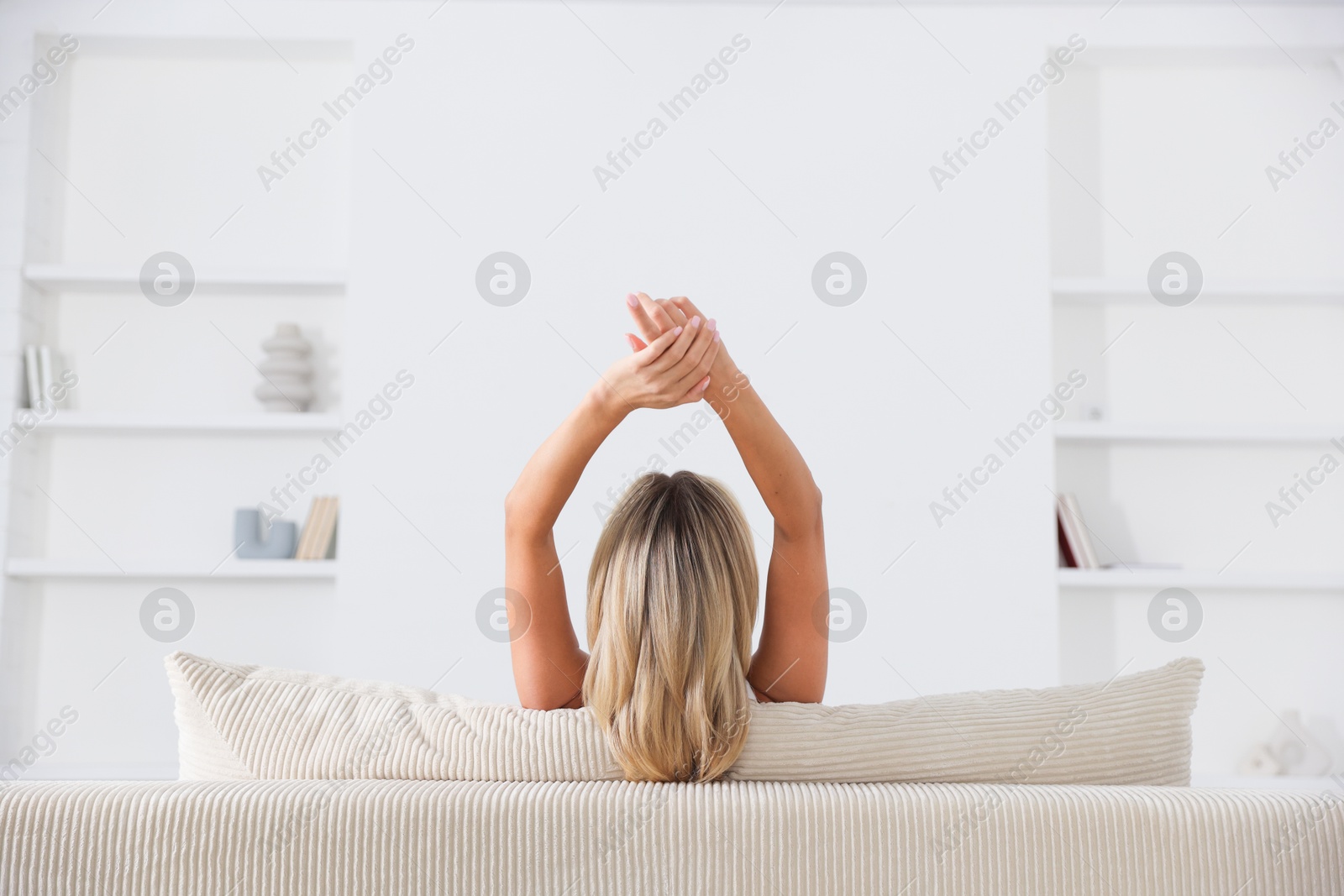 Beautiful woman relaxing on sofa at home, back view Photo of Beautiful woman relaxing on sofa at home, back view