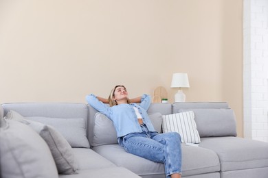 Photo of Beautiful woman relaxing on sofa at home