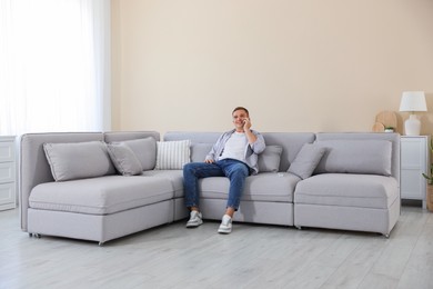 Photo of Young man talking on phone at home