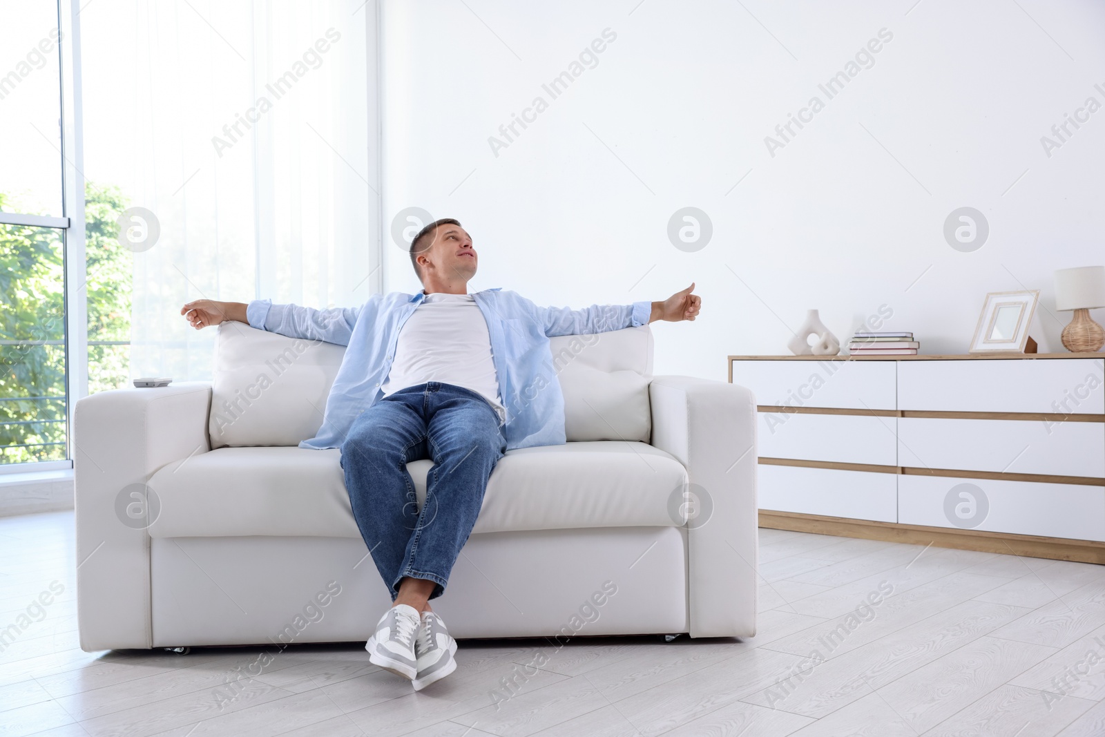 Young man relaxing on sofa at home Photo of Young man relaxing on sofa at home