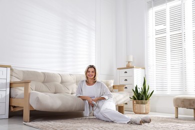Photo of Woman with air conditioner remote control at home
