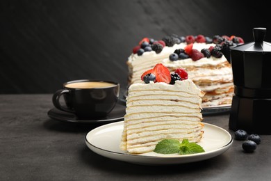 Photo of Piece of tasty crepe cake with berries served on grey table, closeup. Space for text