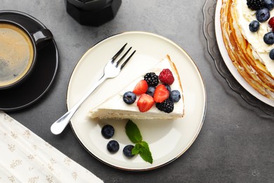 Photo of Piece of tasty crepe cake with berries served on grey table, flat lay