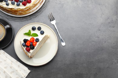 Photo of Piece of tasty crepe cake with berries served on grey table, flat lay. Space for text