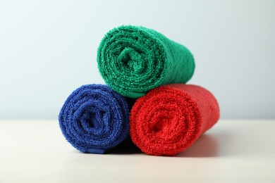 Photo of Colorful fresh terry towels on white table, closeup