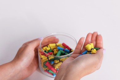 Photo of Woman with glass jar of colorful paper pieces at white table, closeup