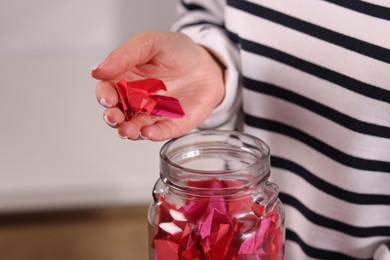 Photo of Woman with colorful paper pieces on blurred background, closeup
