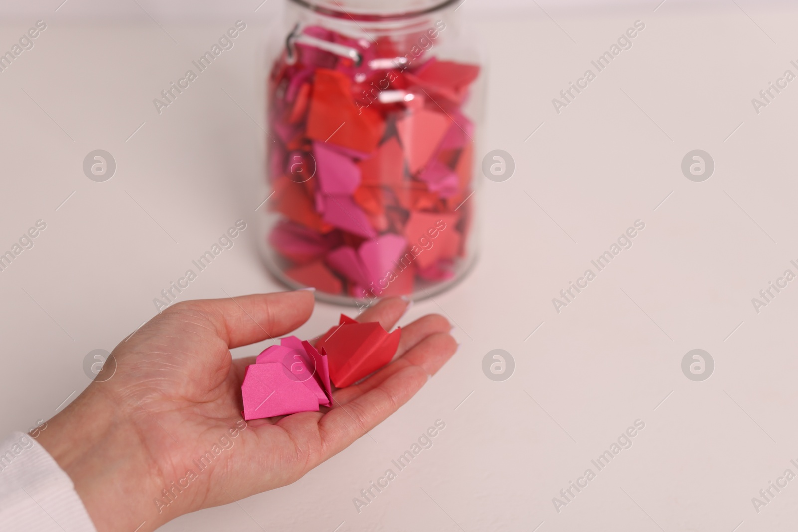 Woman with colorful paper pieces at white table, closeup Photo of Woman with colorful paper pieces at white table, closeup
