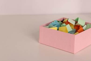 Photo of Color paper pieces in box on light table, closeup. Space for text