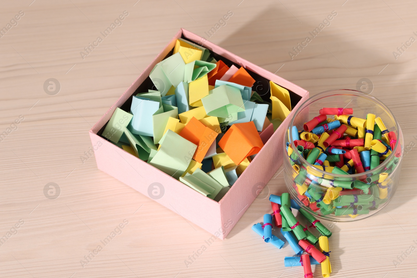 Color paper pieces on light wooden table, above view Photo of Color paper pieces on light wooden table, above view