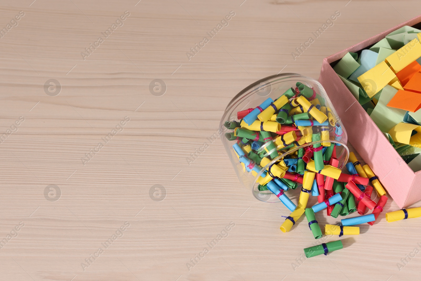 Color paper pieces on light wooden table, above view. Space for text Photo of Color paper pieces on light wooden table, above view. Space for text