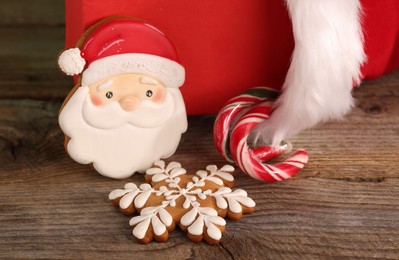 Photo of Saint Nicholas day tradition. Beautiful decorated gingerbread cookies and candy canes on wooden table, closeup