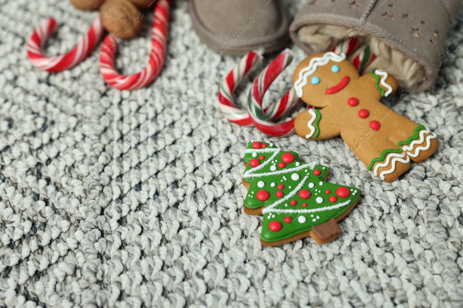 Photo of Saint Nicholas day tradition. Boots with sweets on floor indoors, closeup. Space for text