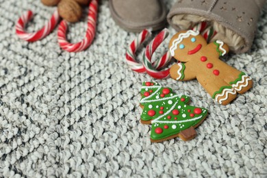 Photo of Saint Nicholas day tradition. Boots with sweets on floor indoors, closeup. Space for text