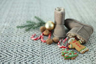 Photo of Saint Nicholas day tradition. Boots with sweets and festive decor on floor indoors, space for text