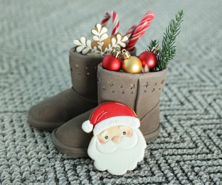 Photo of Saint Nicholas day tradition. Boots with sweets and festive decor on floor indoors