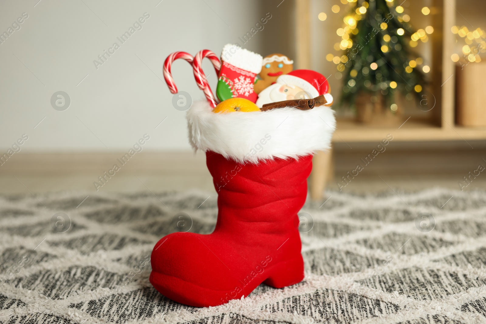 Photo of Saint Nicholas Day tradition. Red boot with treats in room