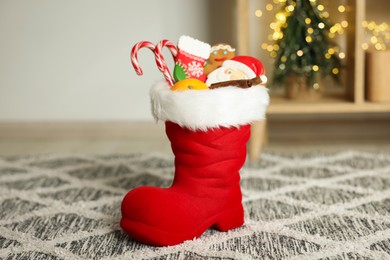 Photo of Saint Nicholas Day tradition. Red boot with treats in room