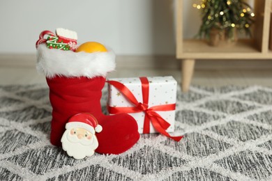 Photo of Saint Nicholas Day tradition. Red boot with treats and gift in room