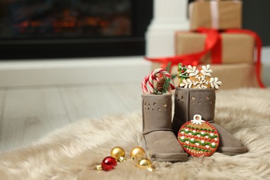 Photo of Saint Nicholas Day tradition. Child's boots with treats and ornaments in room, space for text
