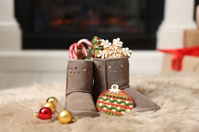 Photo of Saint Nicholas Day tradition. Child's boots with treats and ornaments in room