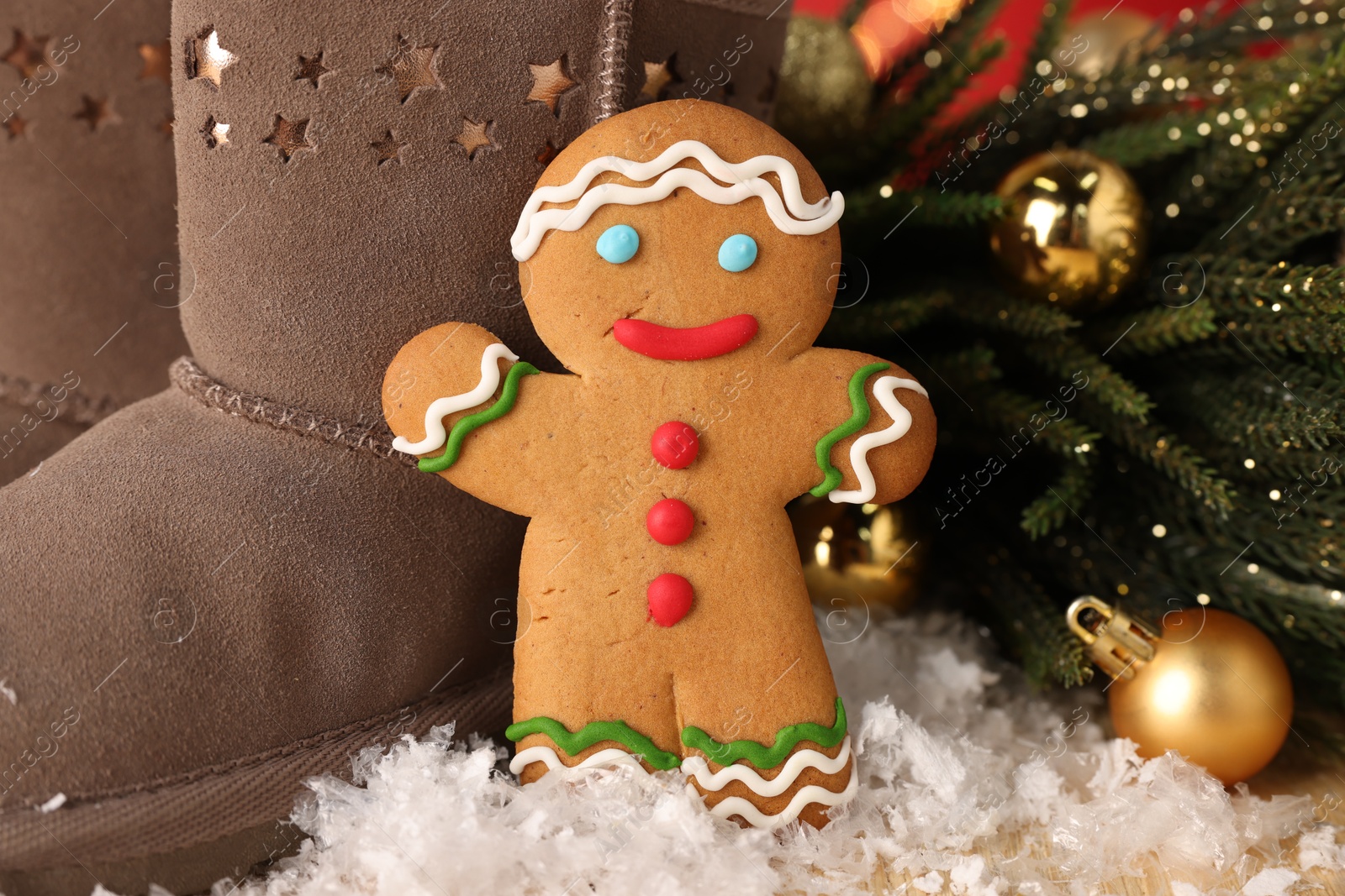 Photo of Saint Nicholas day. Gingerbread man, boots and festive decor on table, closeup