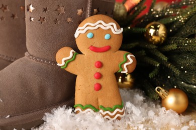 Photo of Saint Nicholas day. Gingerbread man, boots and festive decor on table, closeup