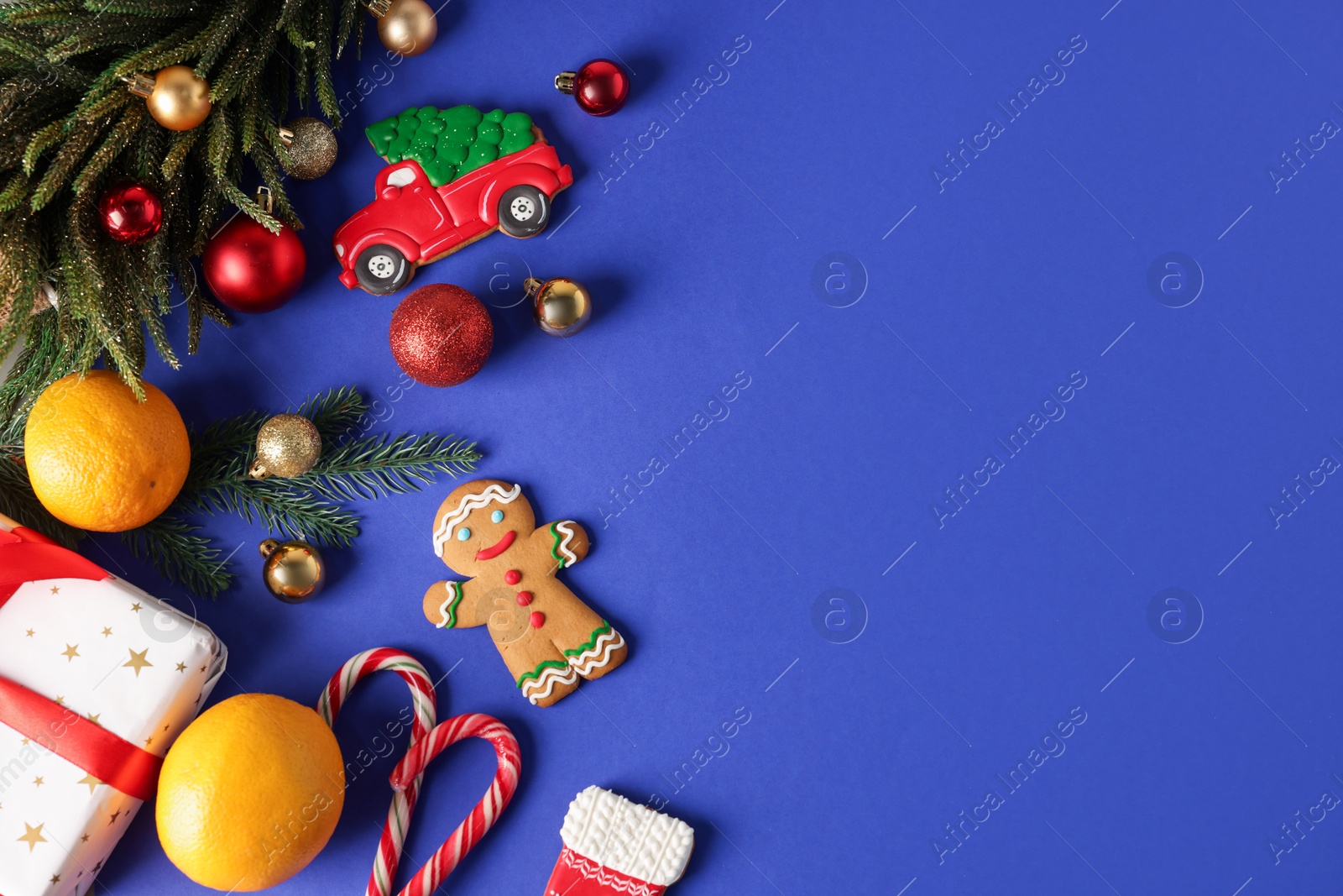 Photo of Saint Nicholas day. Fir tree, ornaments, gift box and treats on blue background, flat lay. Space for text