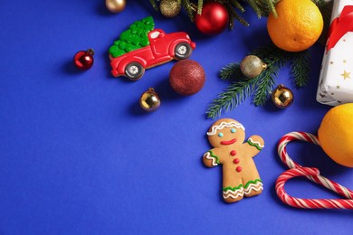 Photo of Saint Nicholas day. Fir branches, ornaments and treats on blue background, flat lay. Space for text