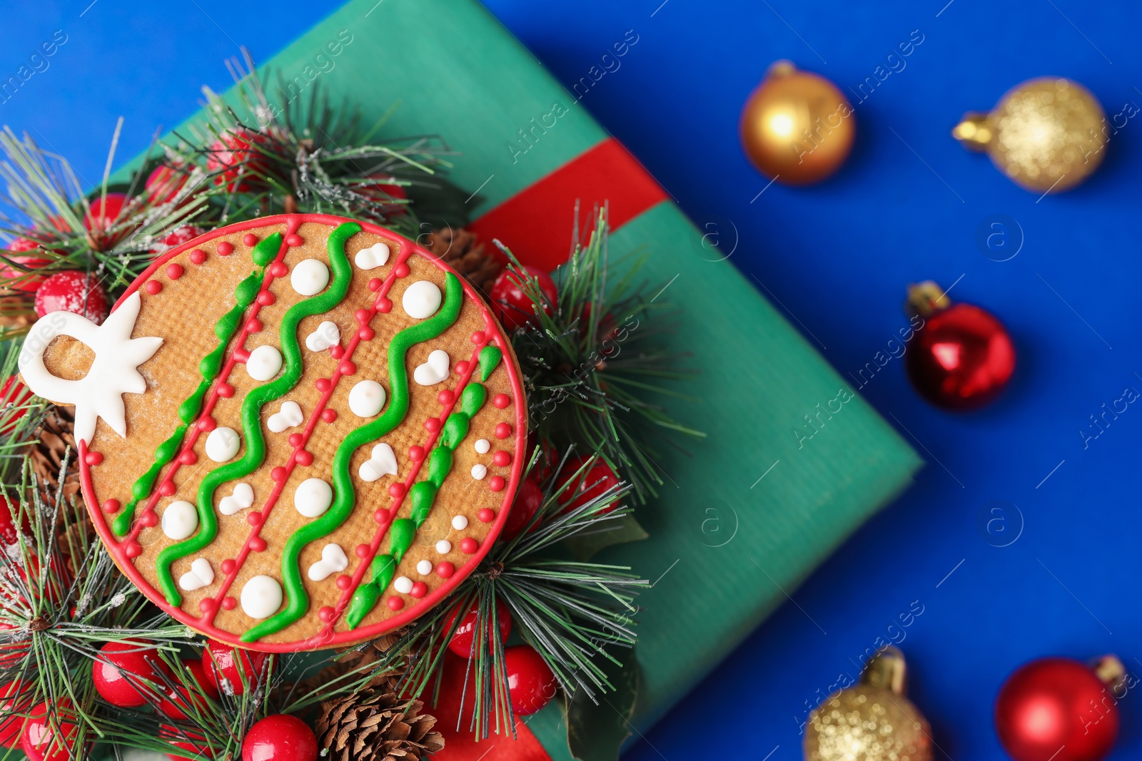 Photo of Saint Nicholas day. Gingerbread cookie, festive decor and gift box on blue background, flat lay