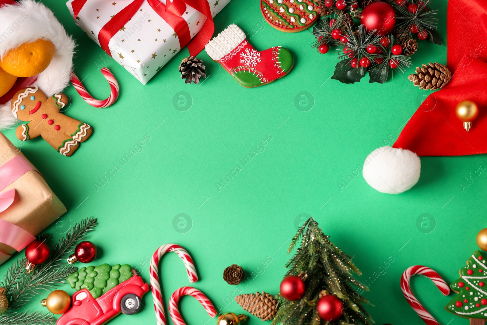 Photo of Saint Nicholas day. Different treats, festive decor and gift boxes on green background, flat lay. Space for text
