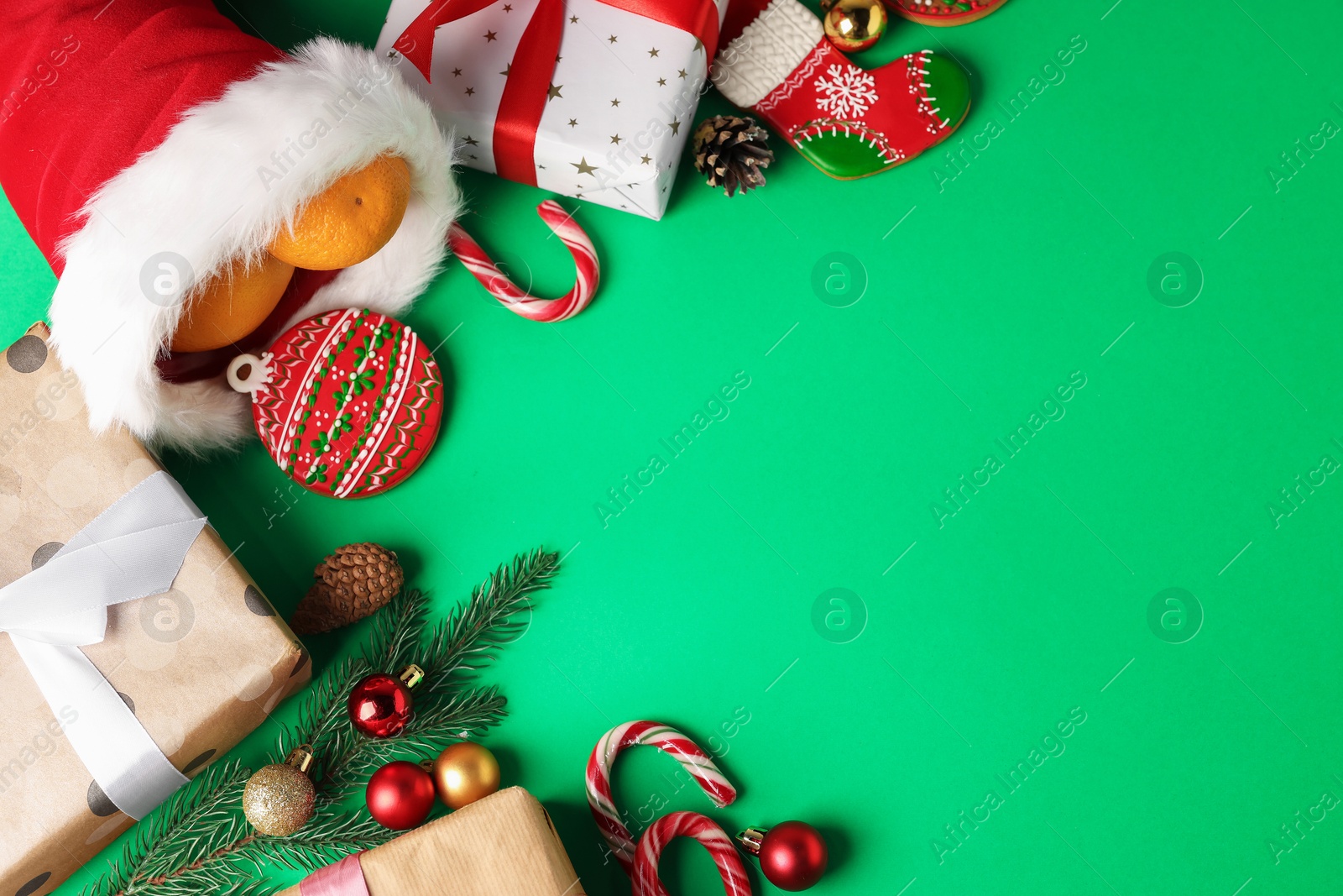 Photo of Saint Nicholas day. Different treats, festive decor and gift boxes on green background, flat lay. Space for text