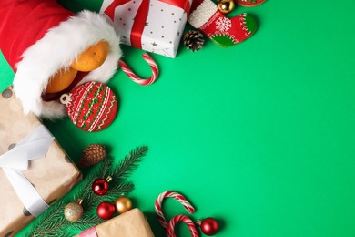 Photo of Saint Nicholas day. Different treats, festive decor and gift boxes on green background, flat lay. Space for text