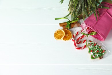 Photo of Happy Saint Nicholas day. Boot, festive decor and sweets on white wooden table, flat lay. Space for text