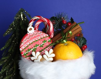 Photo of Happy Saint Nicholas day. Different festive decor, orange and sweets against blue background, closeup