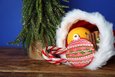 Photo of Happy Saint Nicholas day. Different festive decor and sweets on wooden table against blue background, closeup