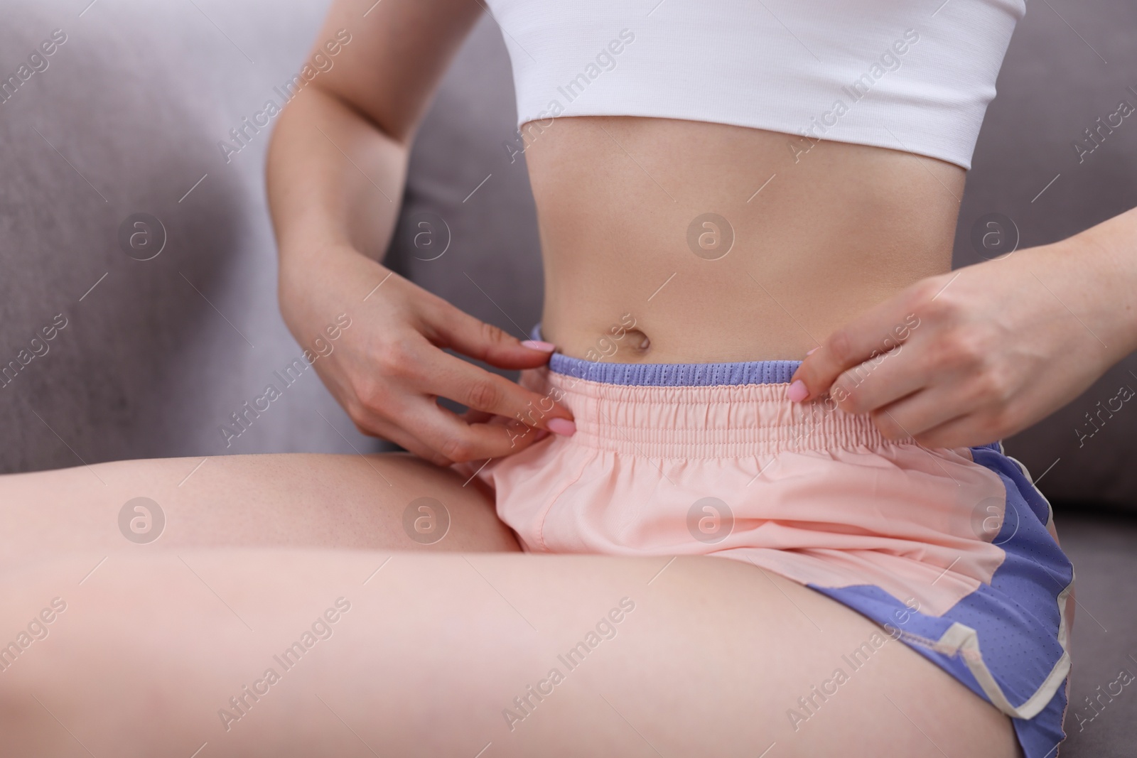 Woman with flat belly on sofa at home, closeup Photo of Woman with flat belly on sofa at home, closeup