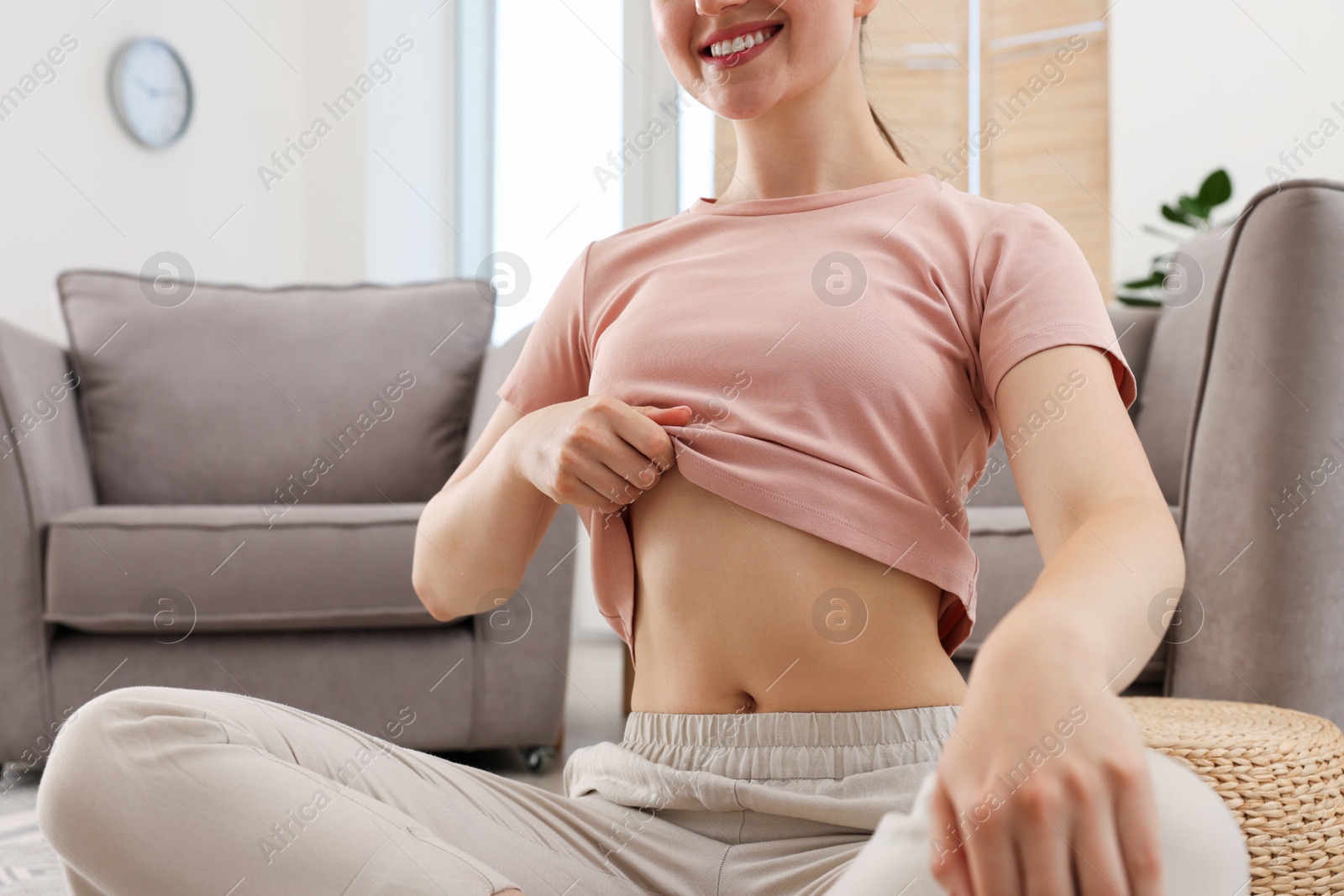 Woman with flat belly on floor at home, closeup Photo of Woman with flat belly on floor at home, closeup