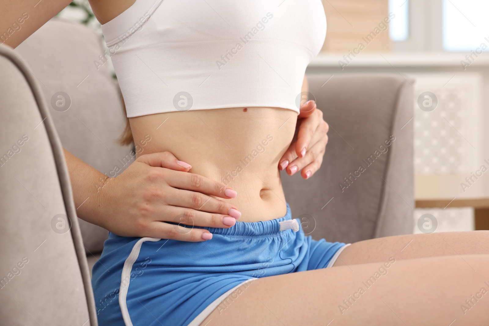 Woman with flat belly on sofa at home, closeup Photo of Woman with flat belly on sofa at home, closeup