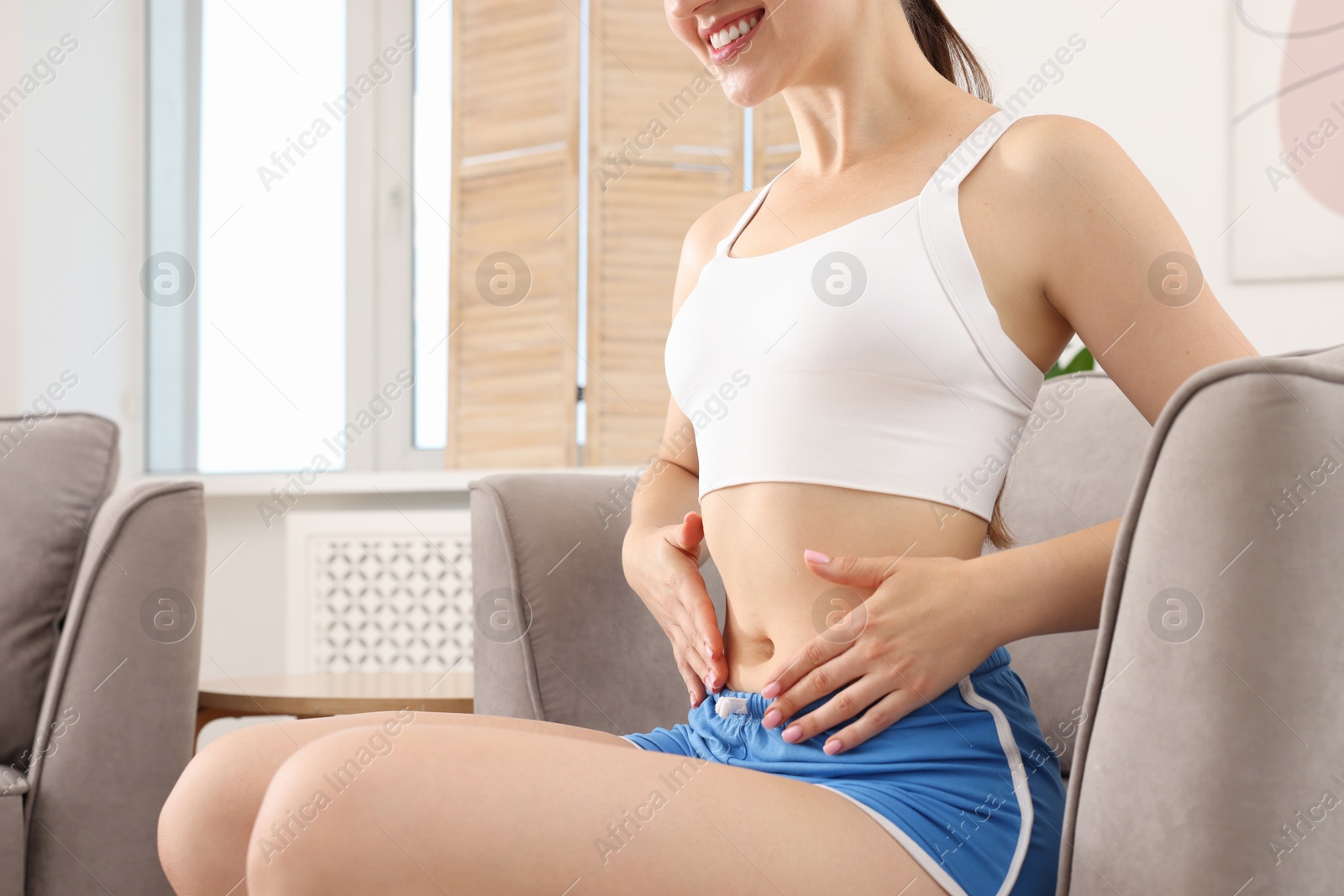 Woman with flat belly on sofa at home, closeup Photo of Woman with flat belly on sofa at home, closeup