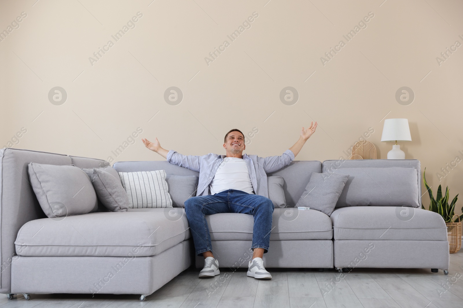 Young man relaxing on sofa at home Photo of Young man relaxing on sofa at home