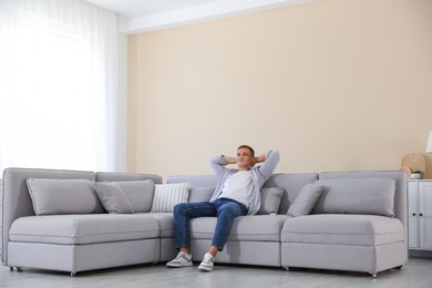 Photo of Young man relaxing on sofa at home