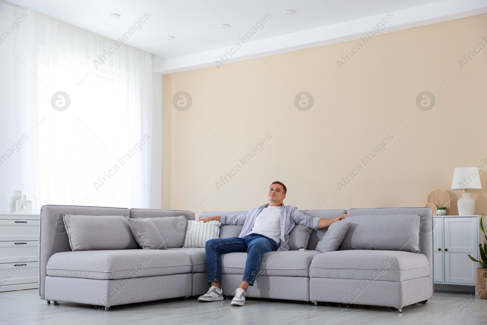 Young man relaxing on sofa at home Photo of Young man relaxing on sofa at home