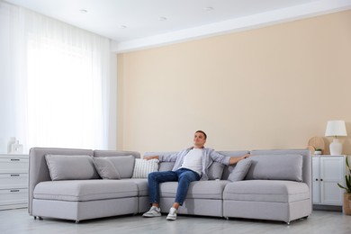 Photo of Young man relaxing on sofa at home