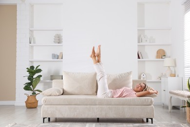 Photo of Beautiful woman relaxing on sofa at home