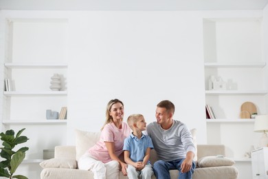 Photo of Happy parents and their son on sofa at home